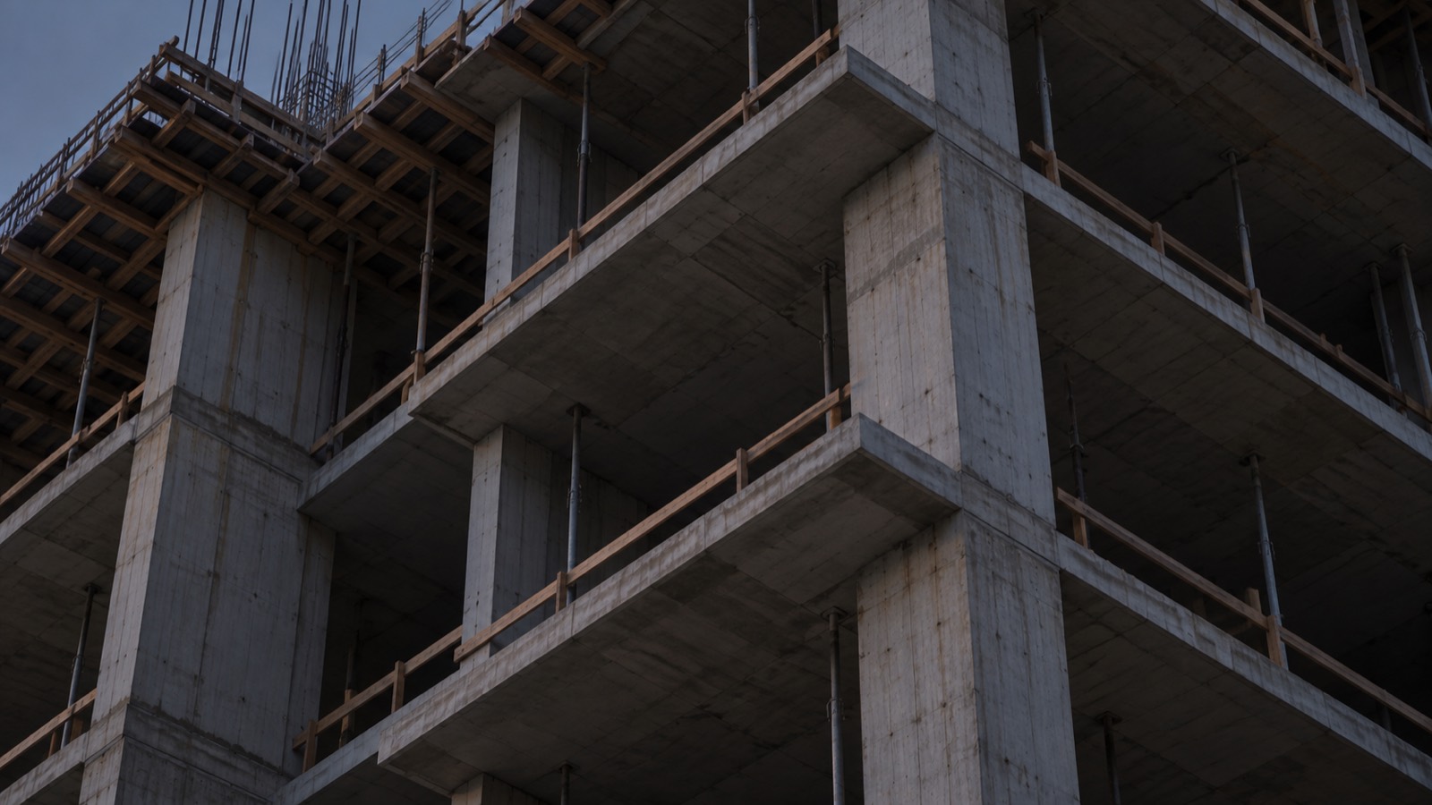 An unfinished concrete residential structure at blue hour
