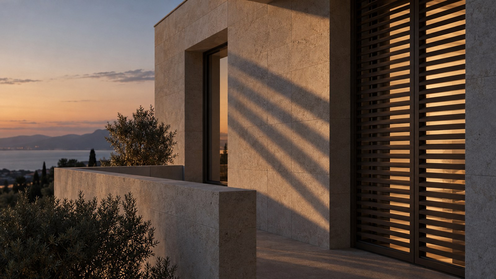A stone residential facade at dusk, long shadows across a shuttered terrace